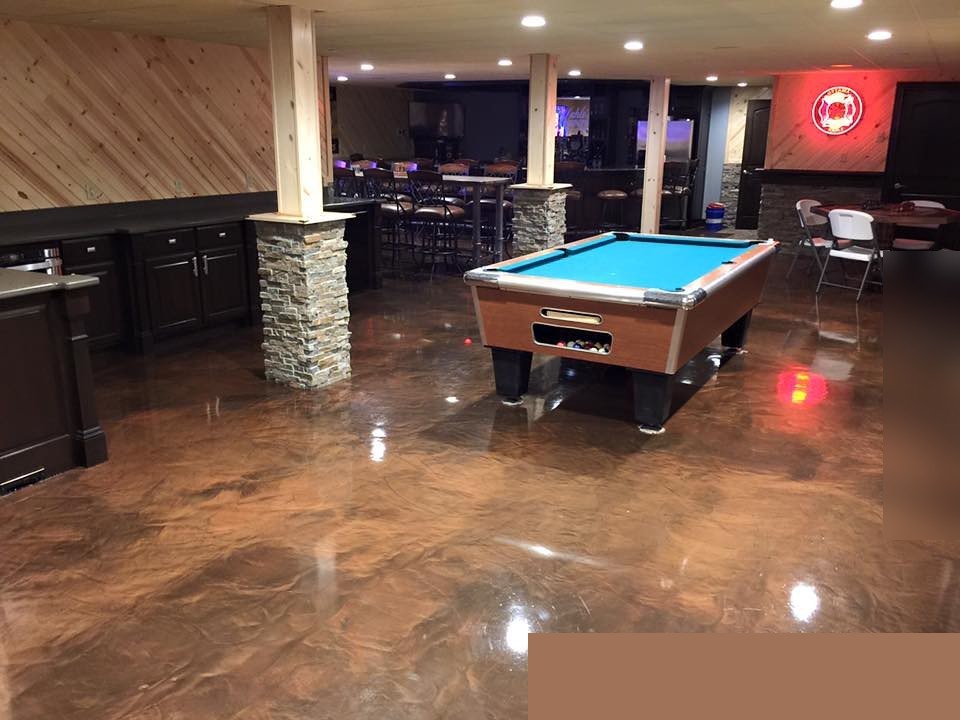 Deep brown metallic epoxy floor in a finished game room